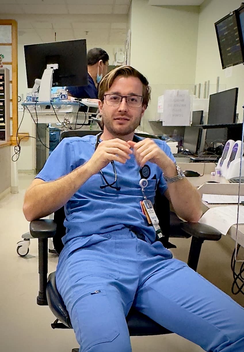 Me in hospital scrubs, exhausted